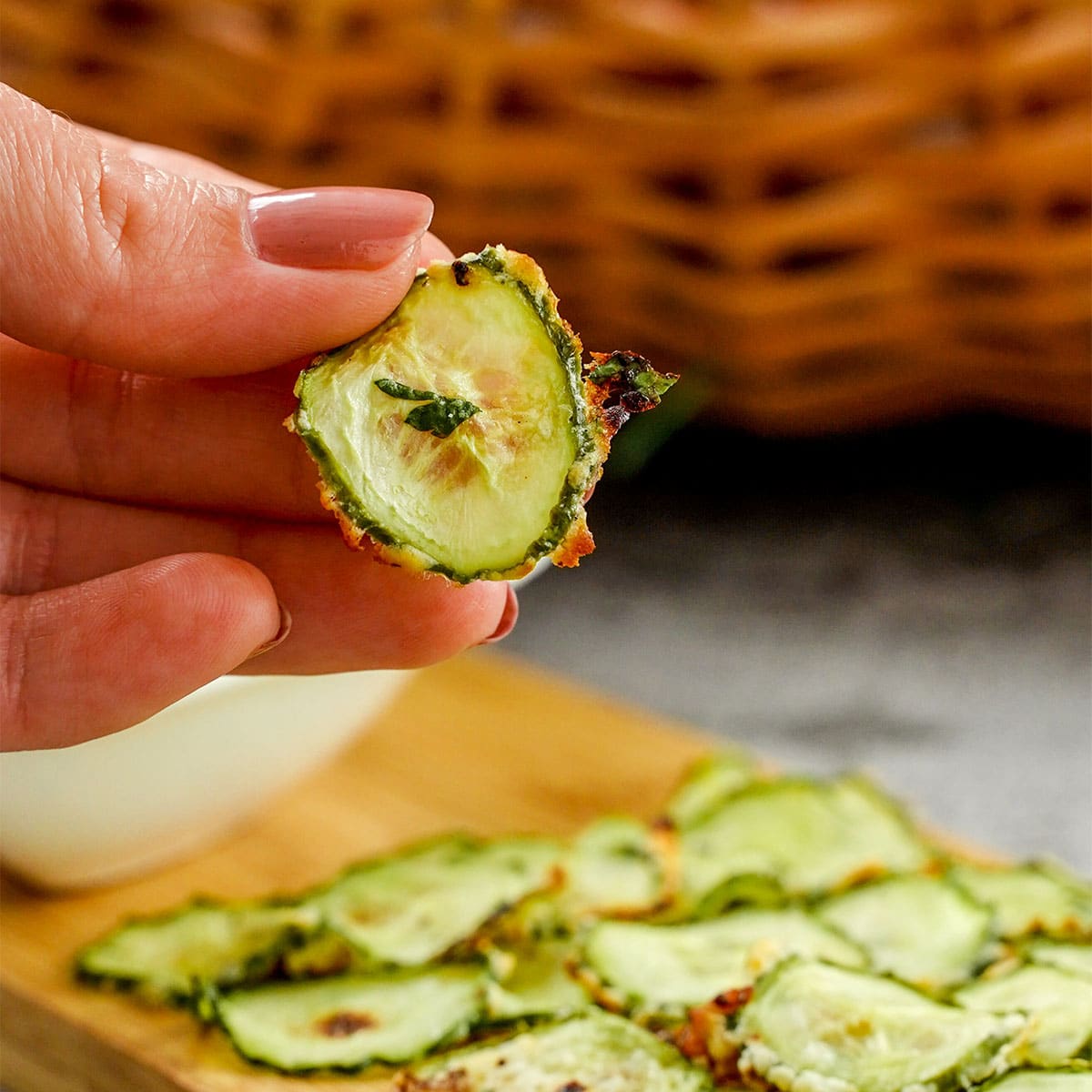 Hand holding homemade cucumber chips