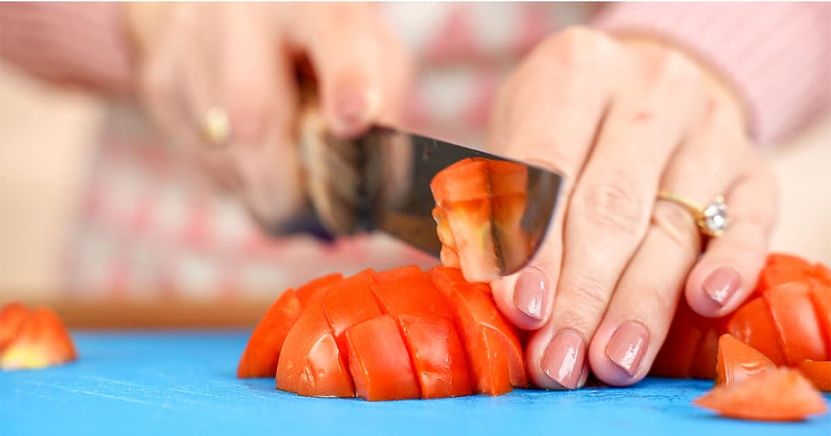 Tomatoes being sliced to make cucumber salad boats