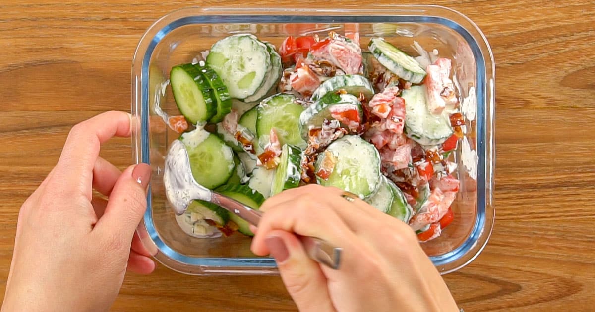 Ingredients being stirred together to make cucumber salad