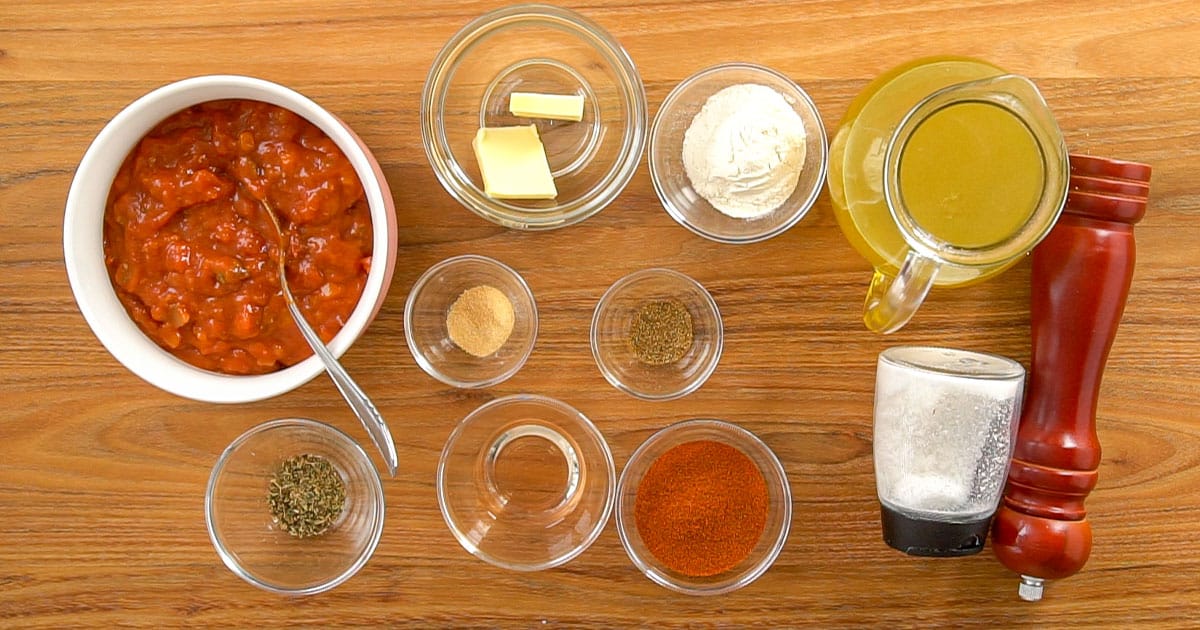 Ingredients necessary to make homemade enchilada sauce in jars