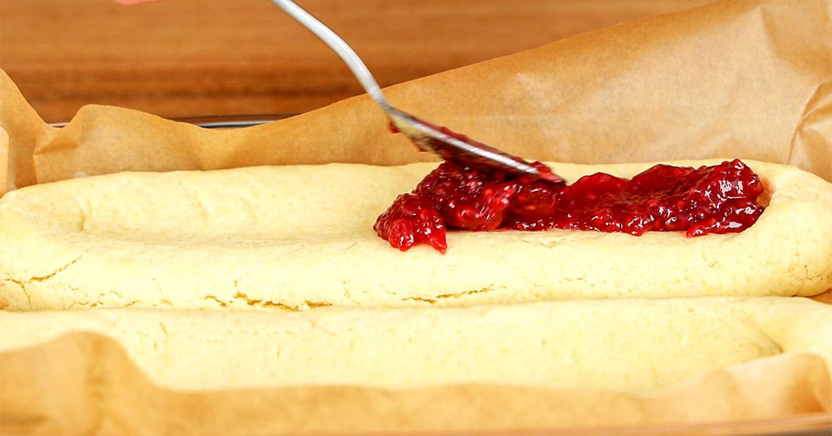 Jelly being added to cookies to make finnish ribbon cookies