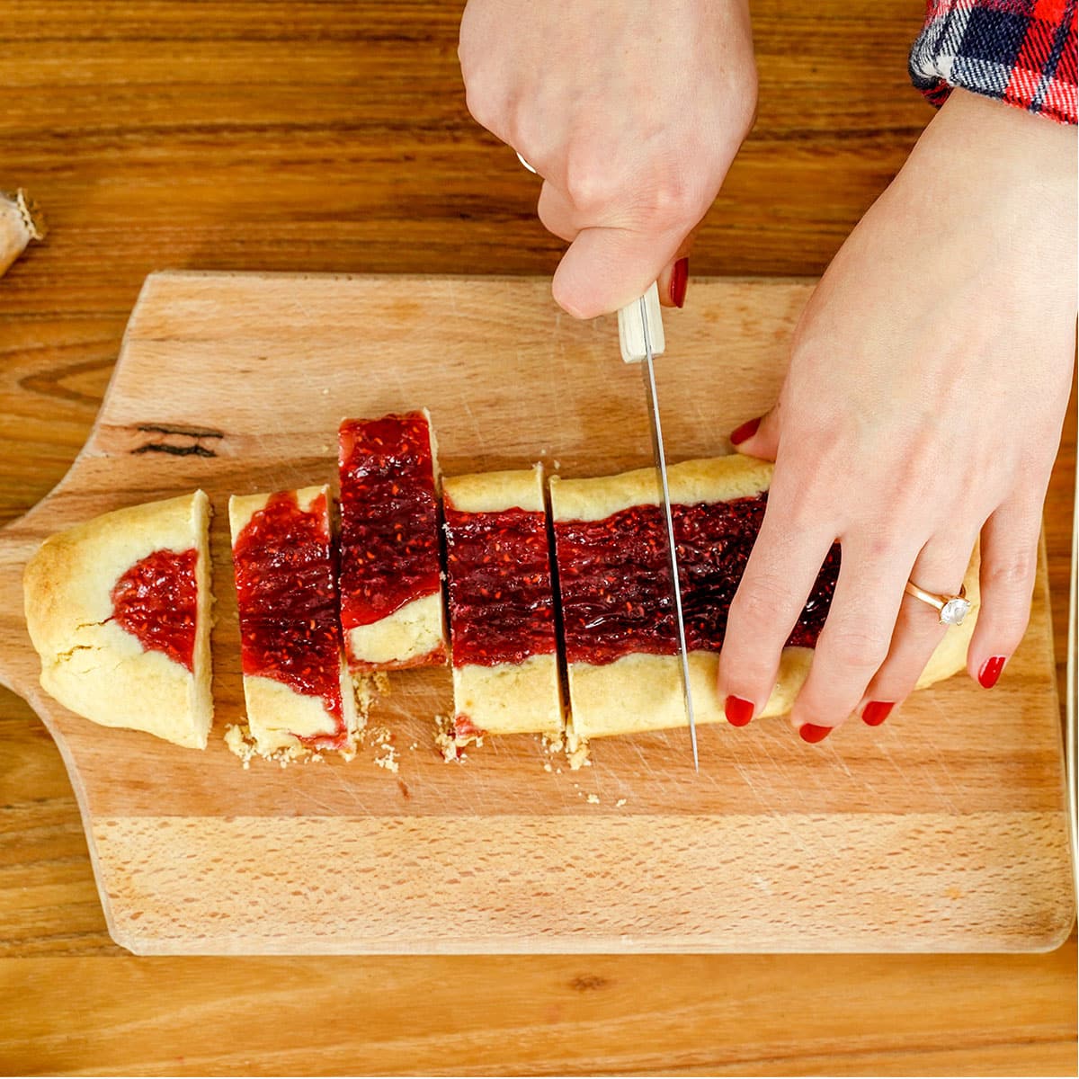 Hands slicing finnish ribbon cookies into ribbons