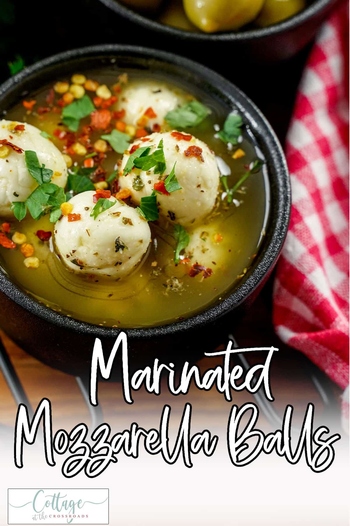 Closeup of bowl of cheese balls with text which reads marinated mozzarella balls