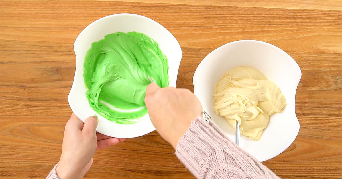 Batter being colored to make old fashioned ribbon cake