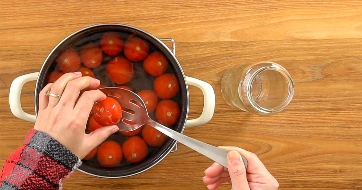 Diy canned tomato recipe being made by cooking the tomatoes