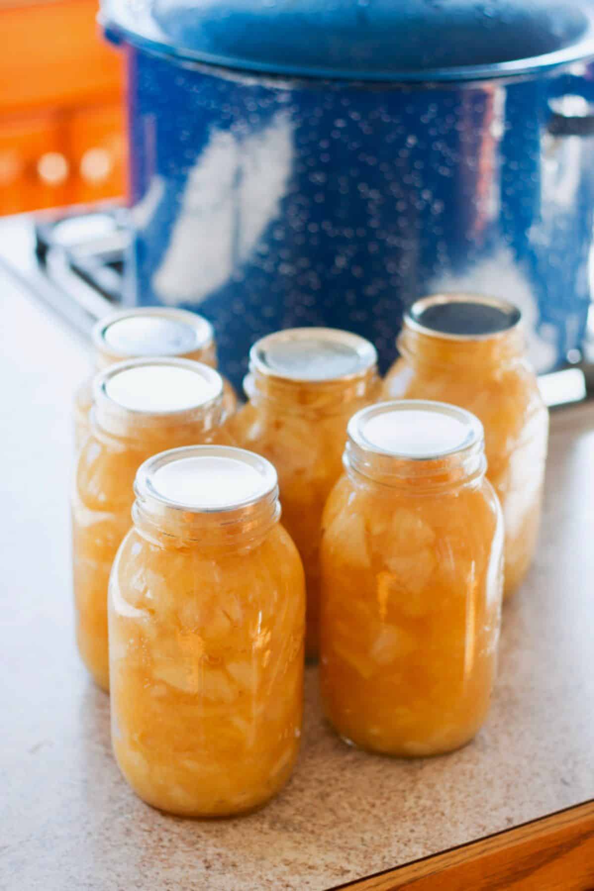 Canned apple pie filling in glass jars.