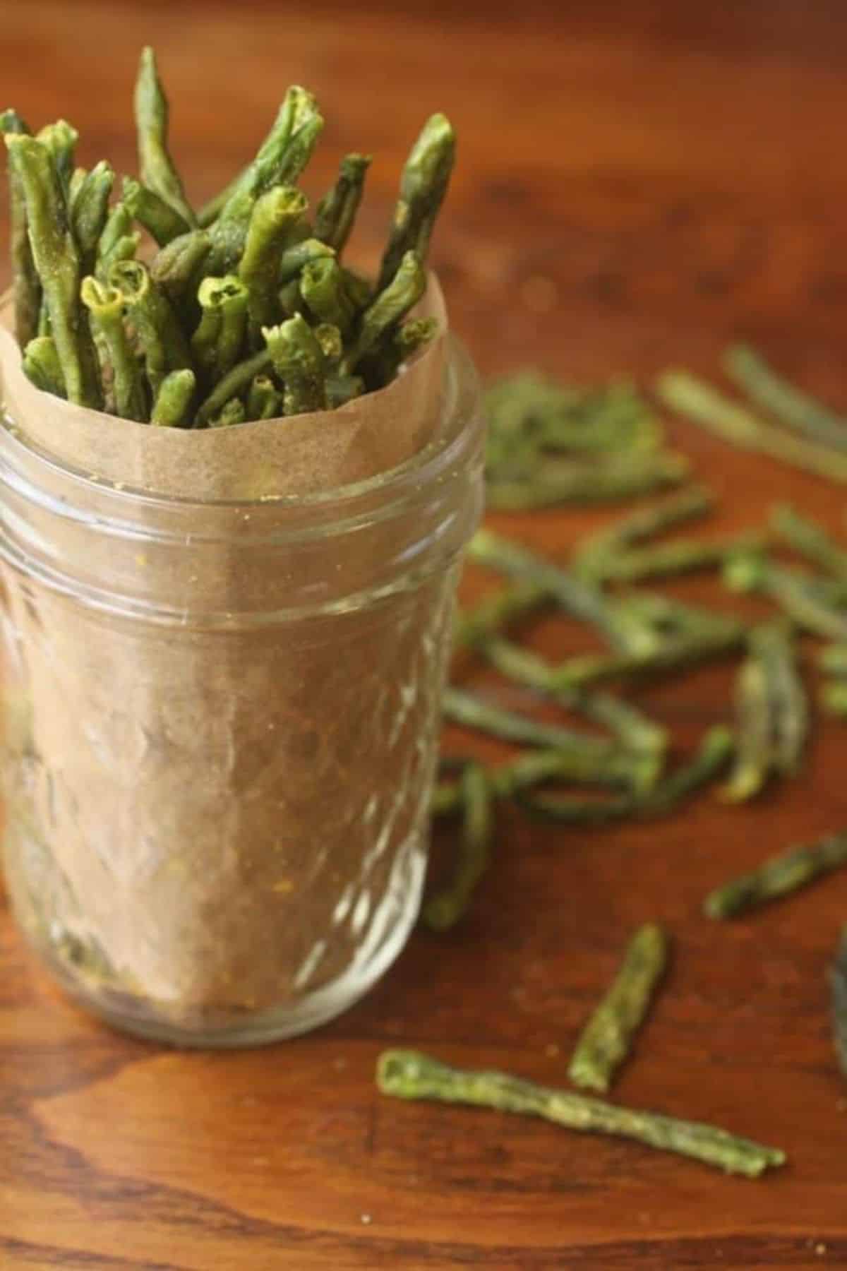 Crispy green bean chips in a glass jar.