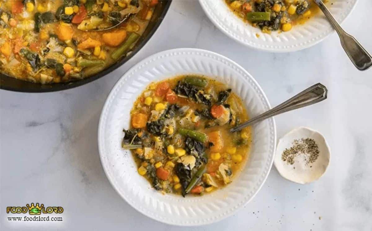 Dry vegetable soup on a white plate with a spoon.