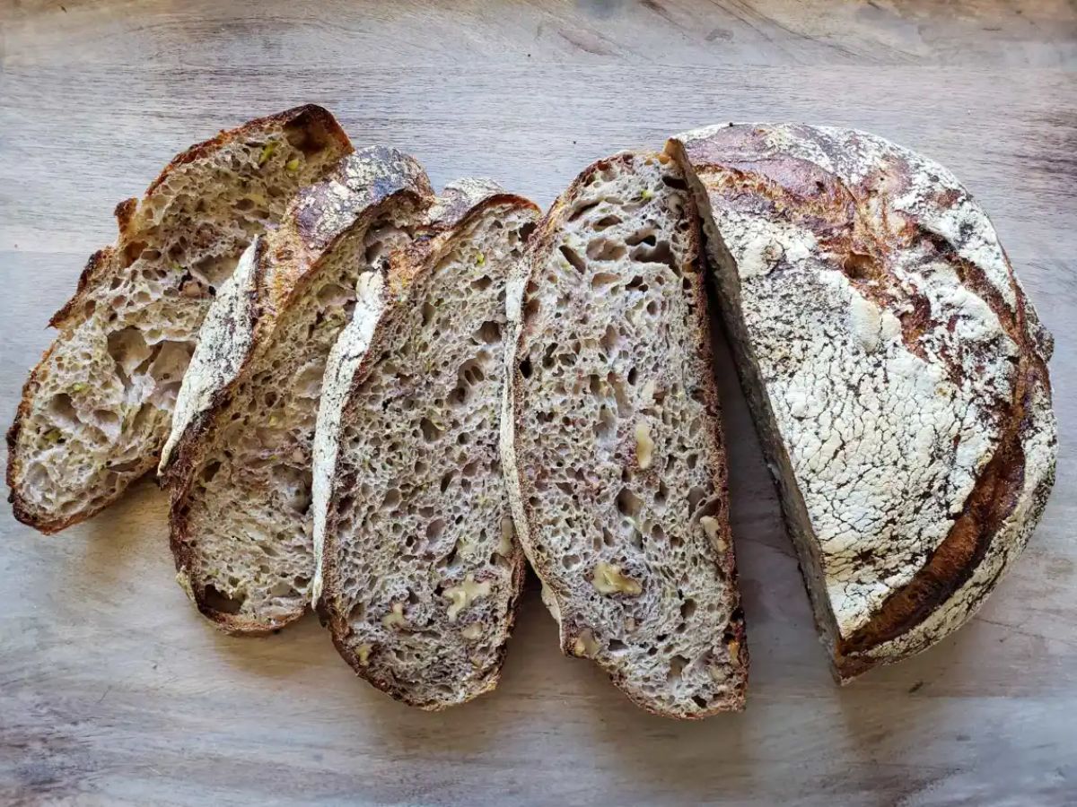 A sliced loaf of rustic zucchini & walnut sourdough bread.