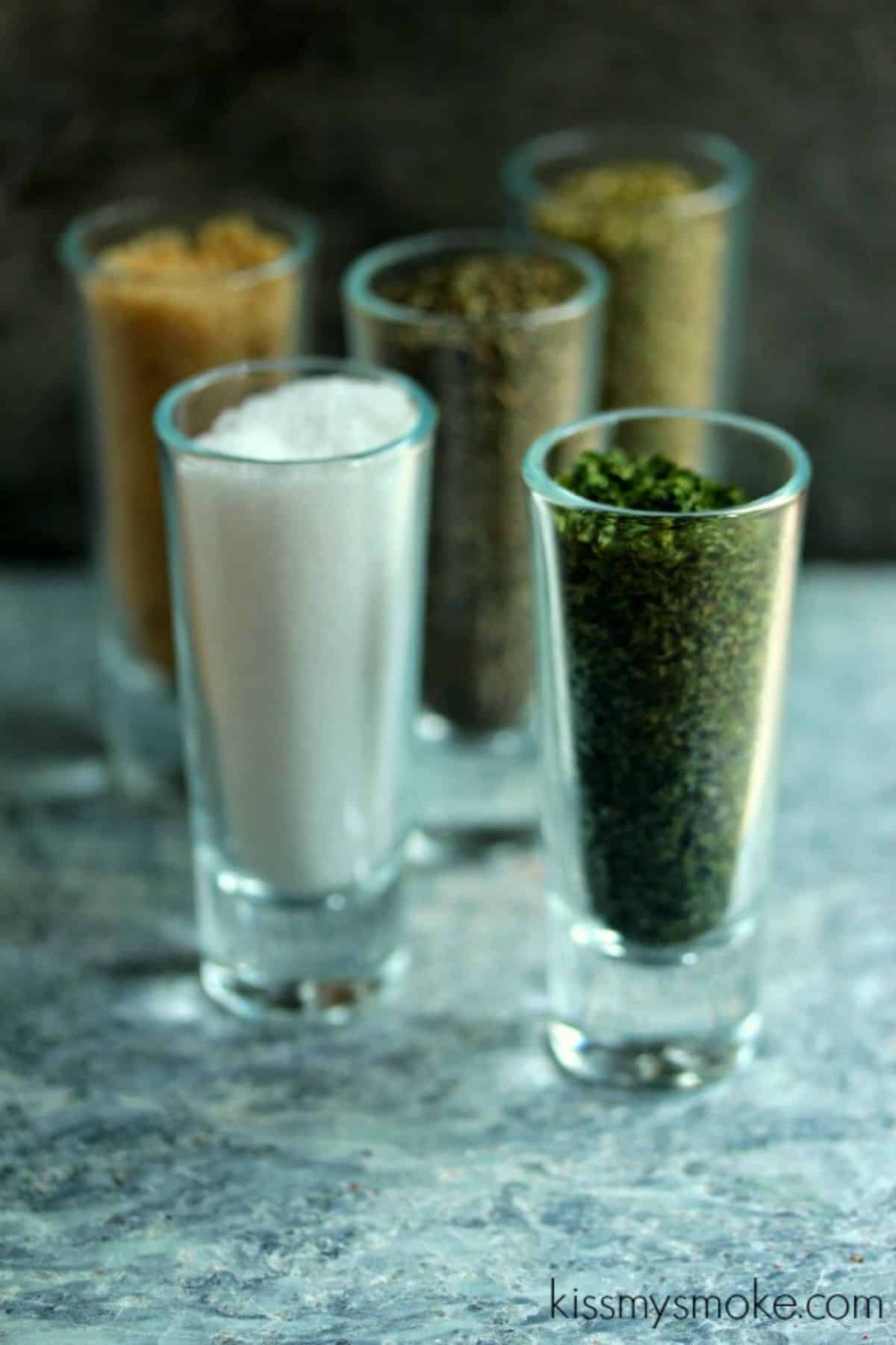 Dried italian herbs in glass shoots.