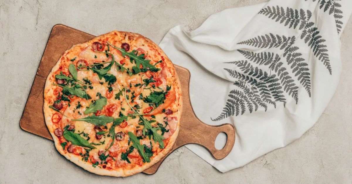 Sourdough pizza crust on a wooden cutting board.