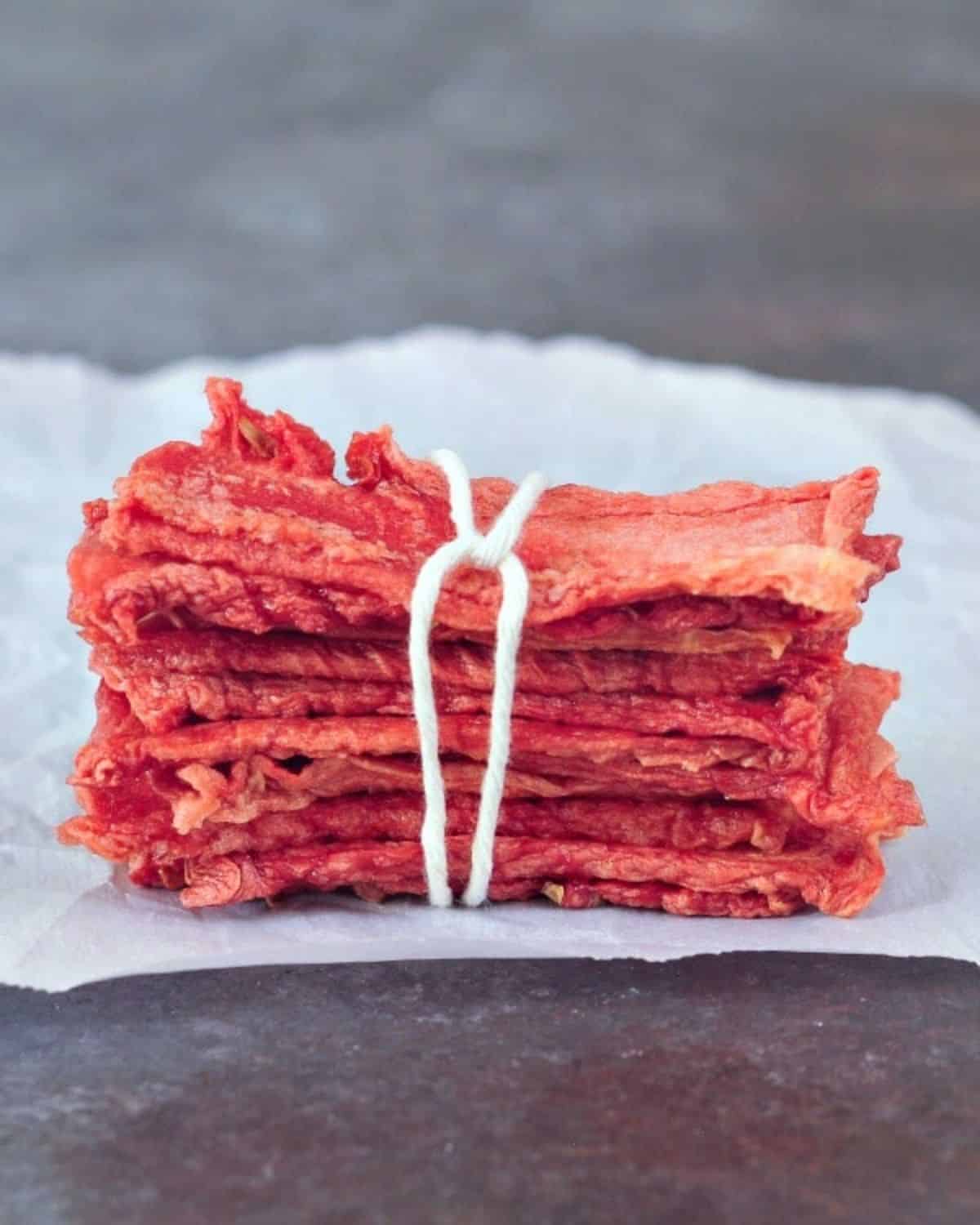 A pack of candied watermelon fruit strips on a piece of paper.