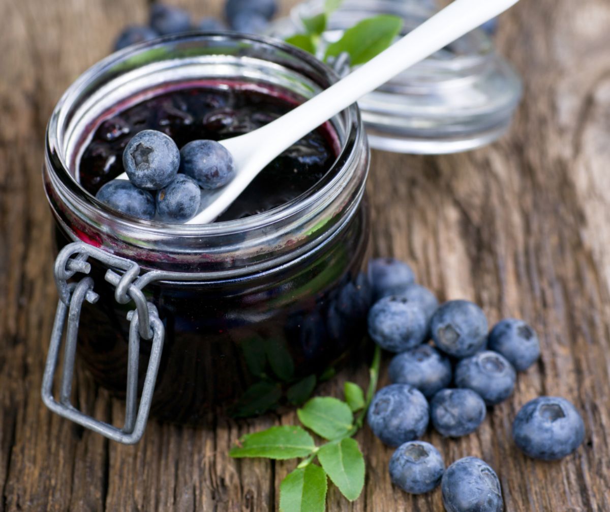 Canned blueberries in syrup in a glass jar.