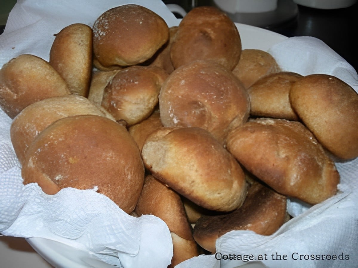 A bunch of crispy whole wheat rolls in a bowl.