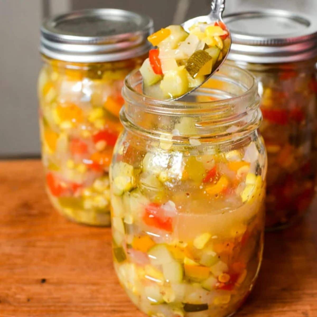 Zucchini corn relish canned in glass jars.