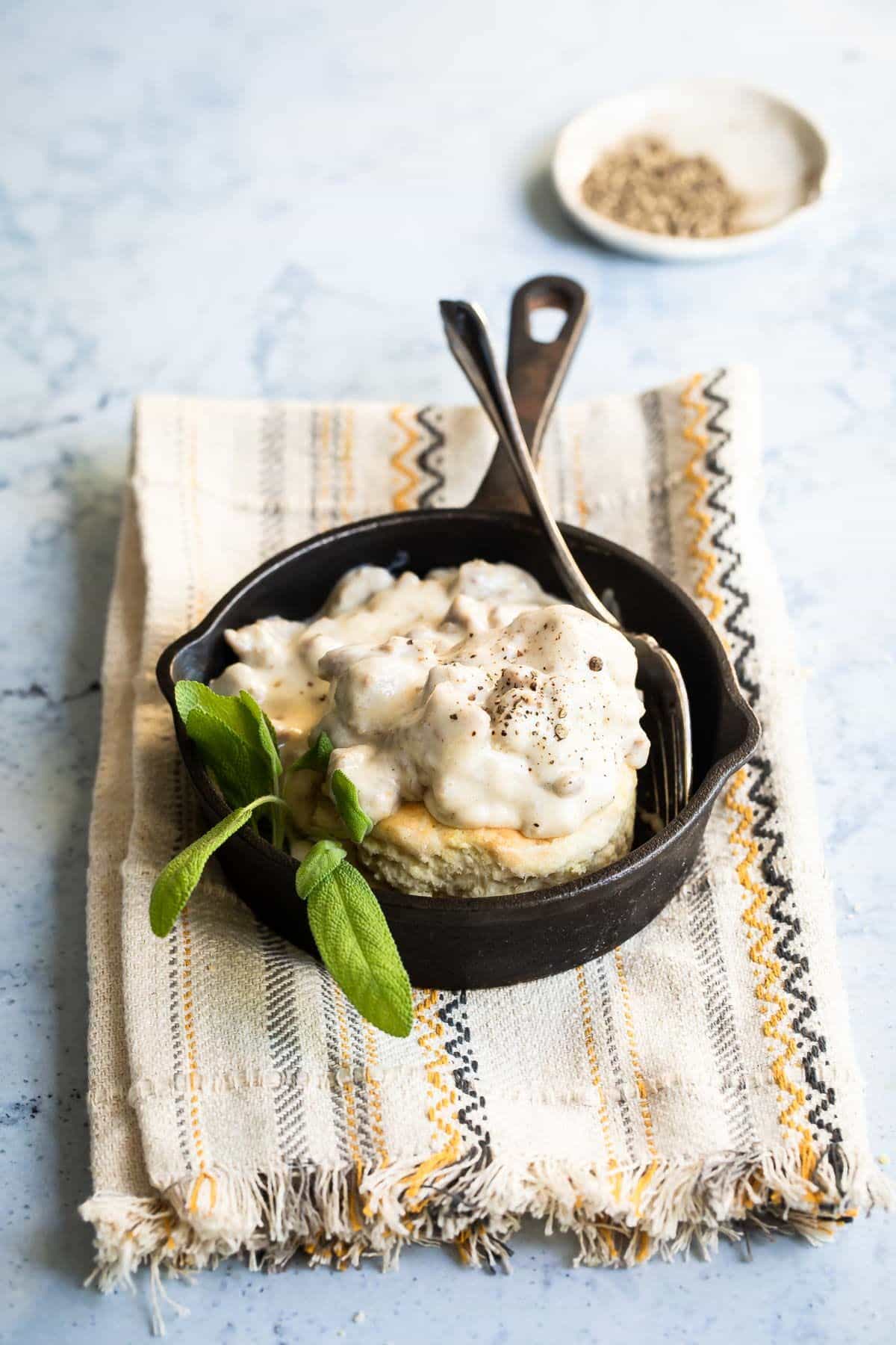 Biscuits and gravy in a black skillet.