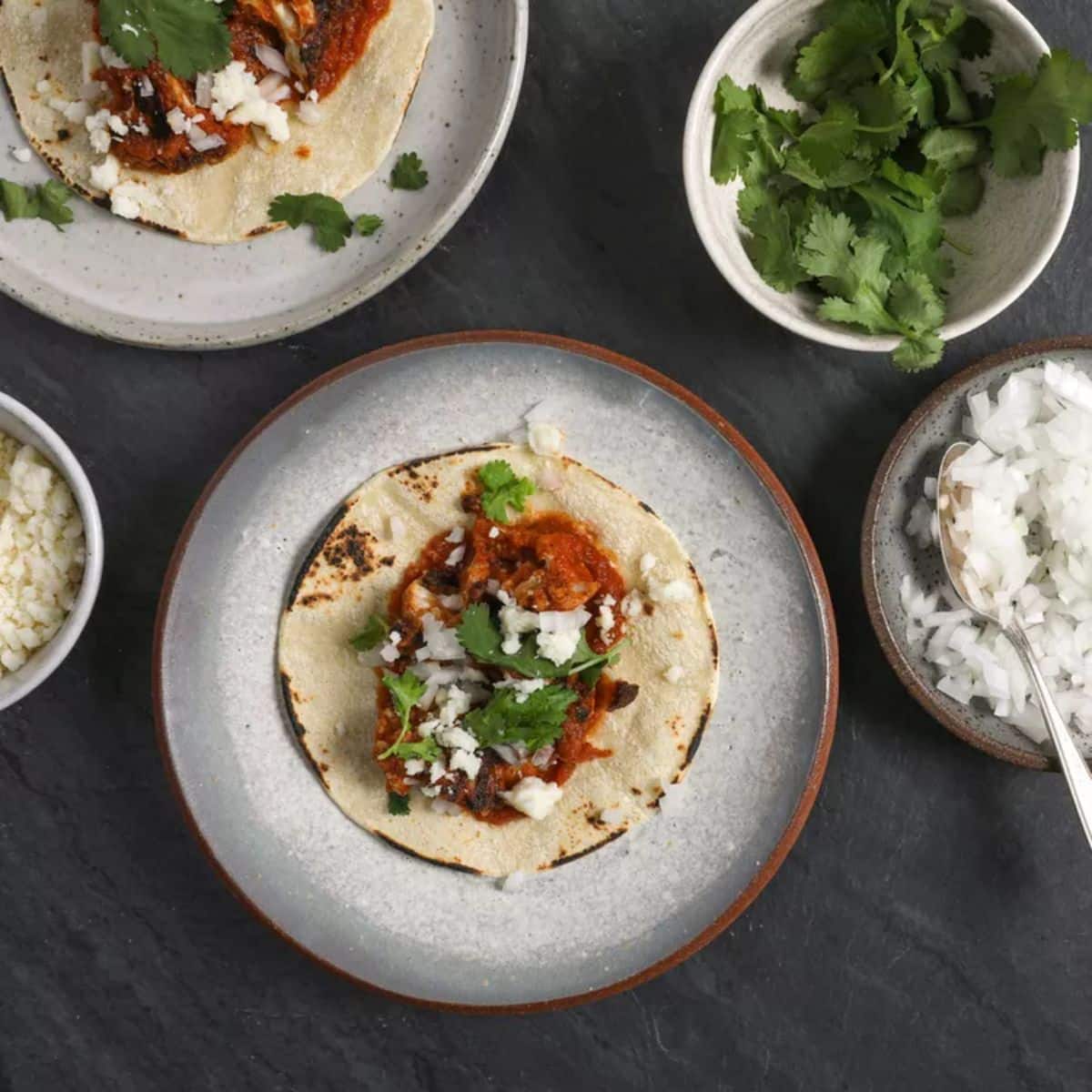 Cauliflower tinga tacos on fancy plates.