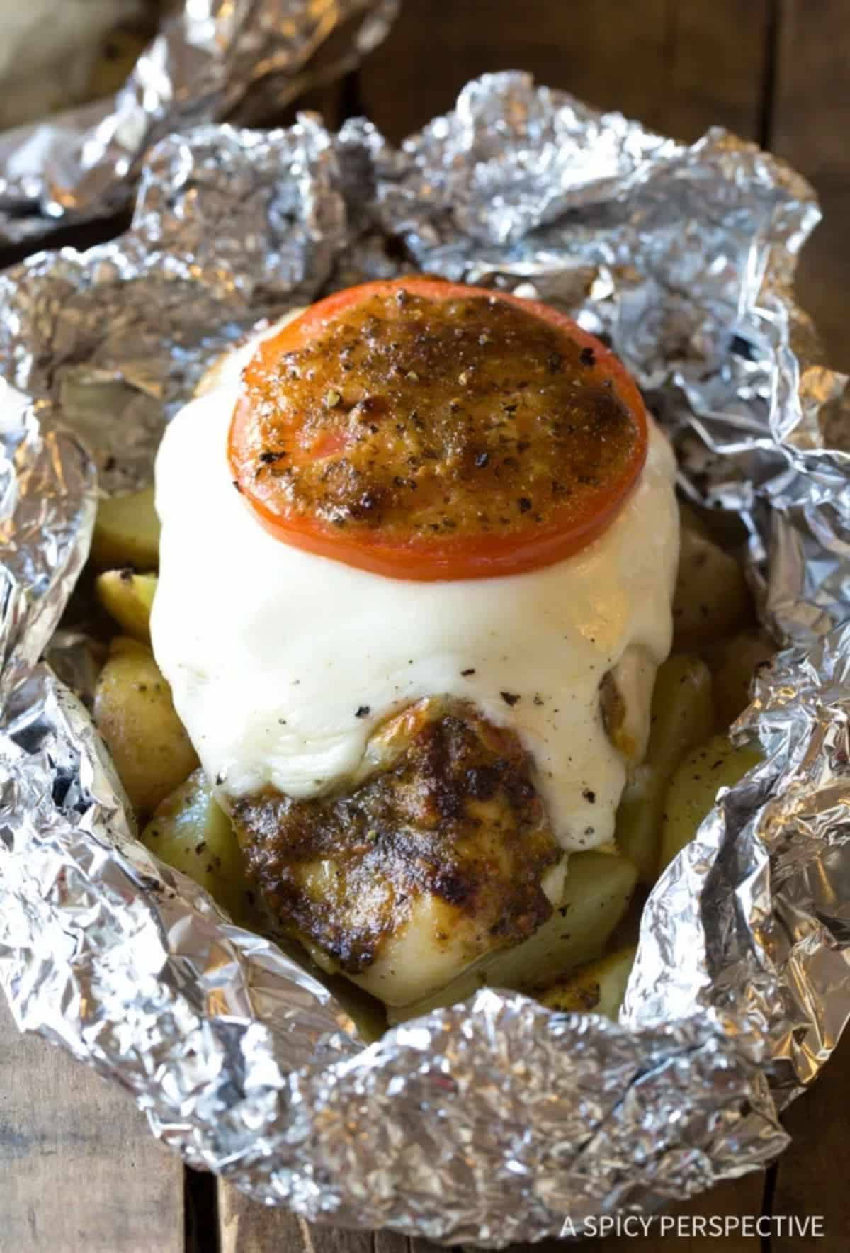 Caprese chicken foil packets in aluminum foil.