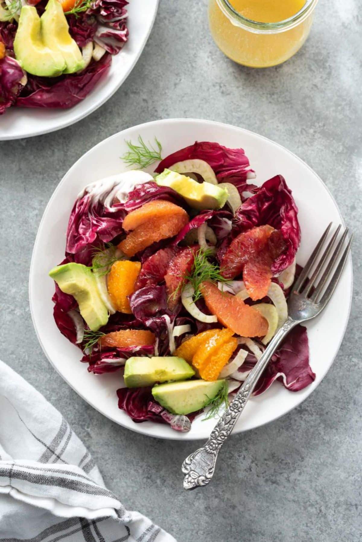 Delicious winter radicchio salad on a white plate with a fork.