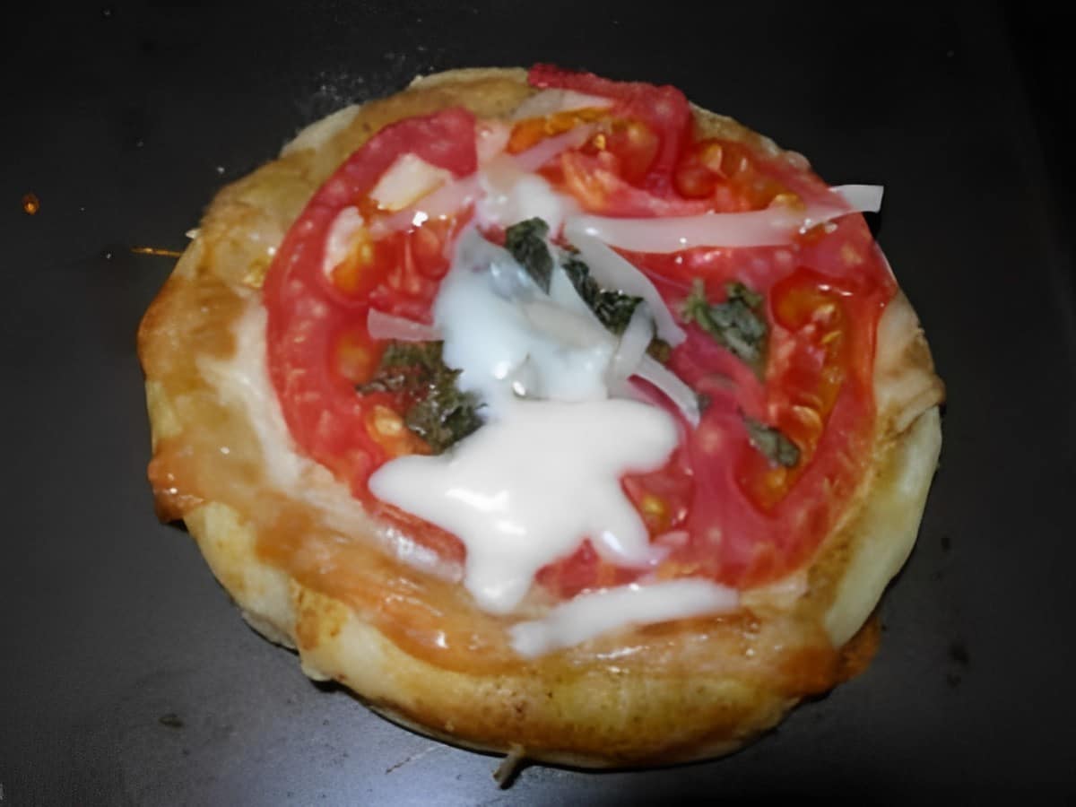 Two cheese tomato puff on a black tray.