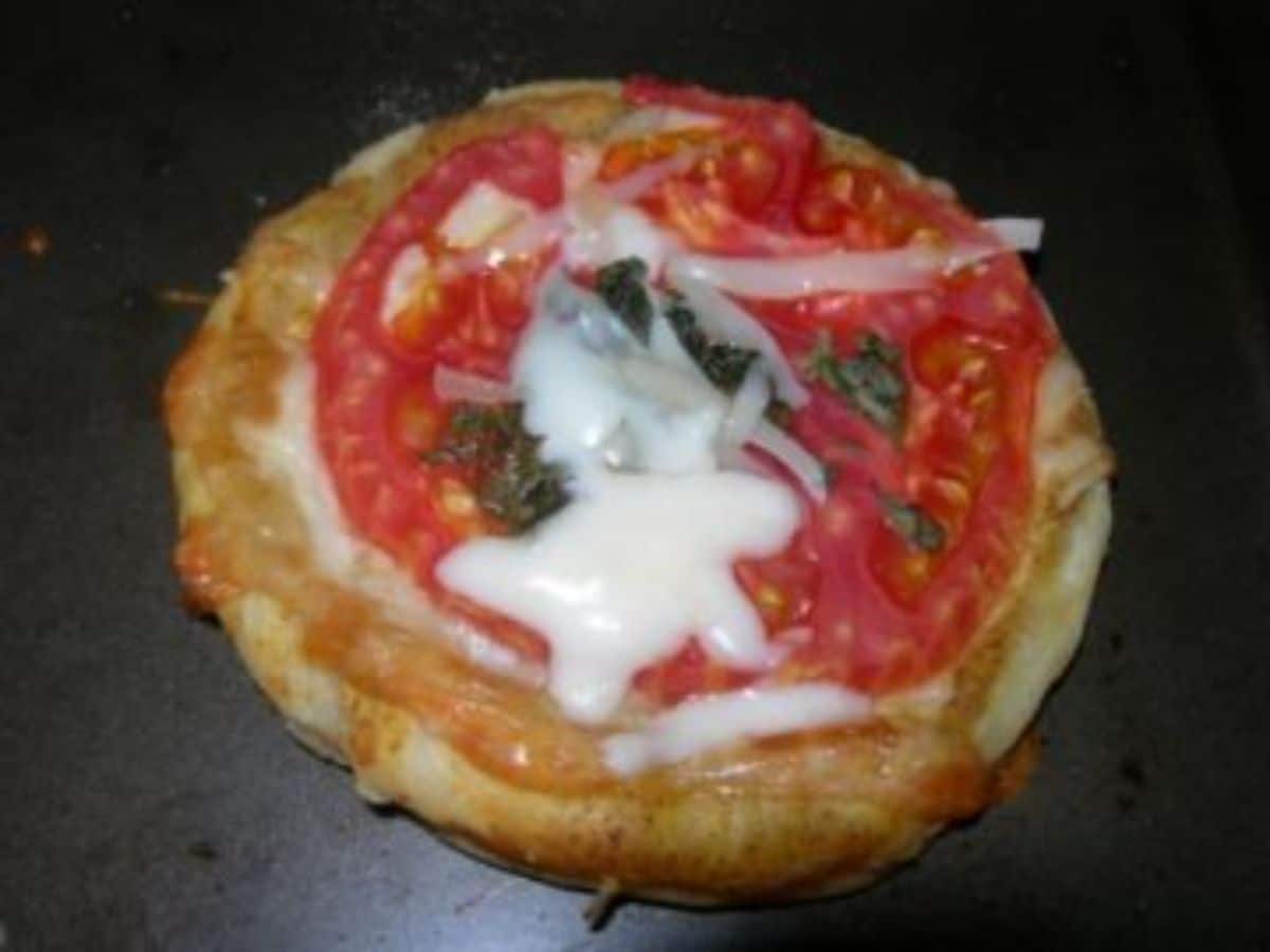 Cheese tomato puff on a black tray.