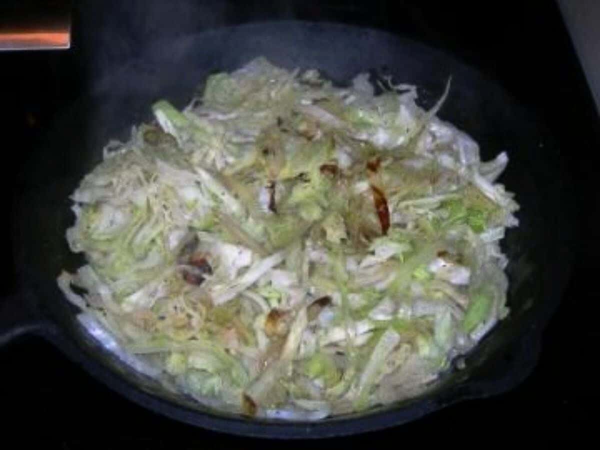 Ina garten's sauteed cabbage in a black bowl.