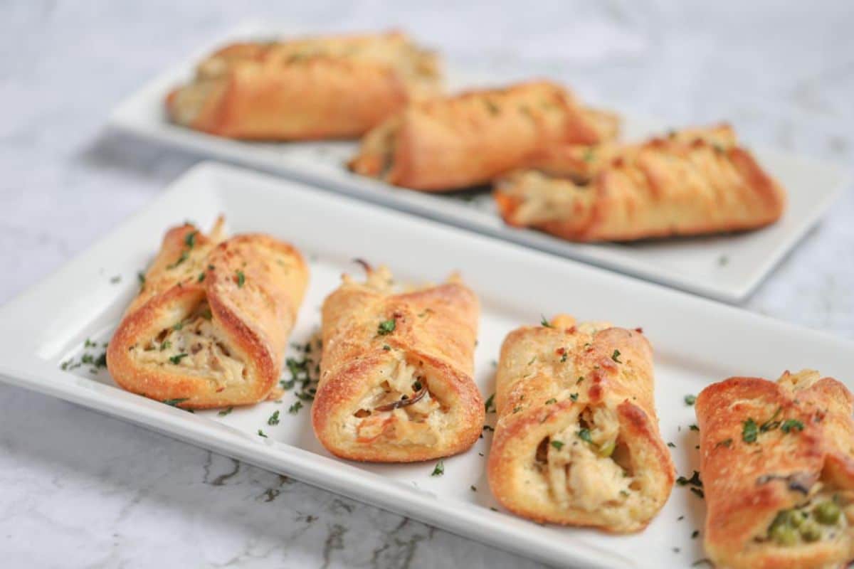 Crunchy chicken pot pie turnovers on white trays.