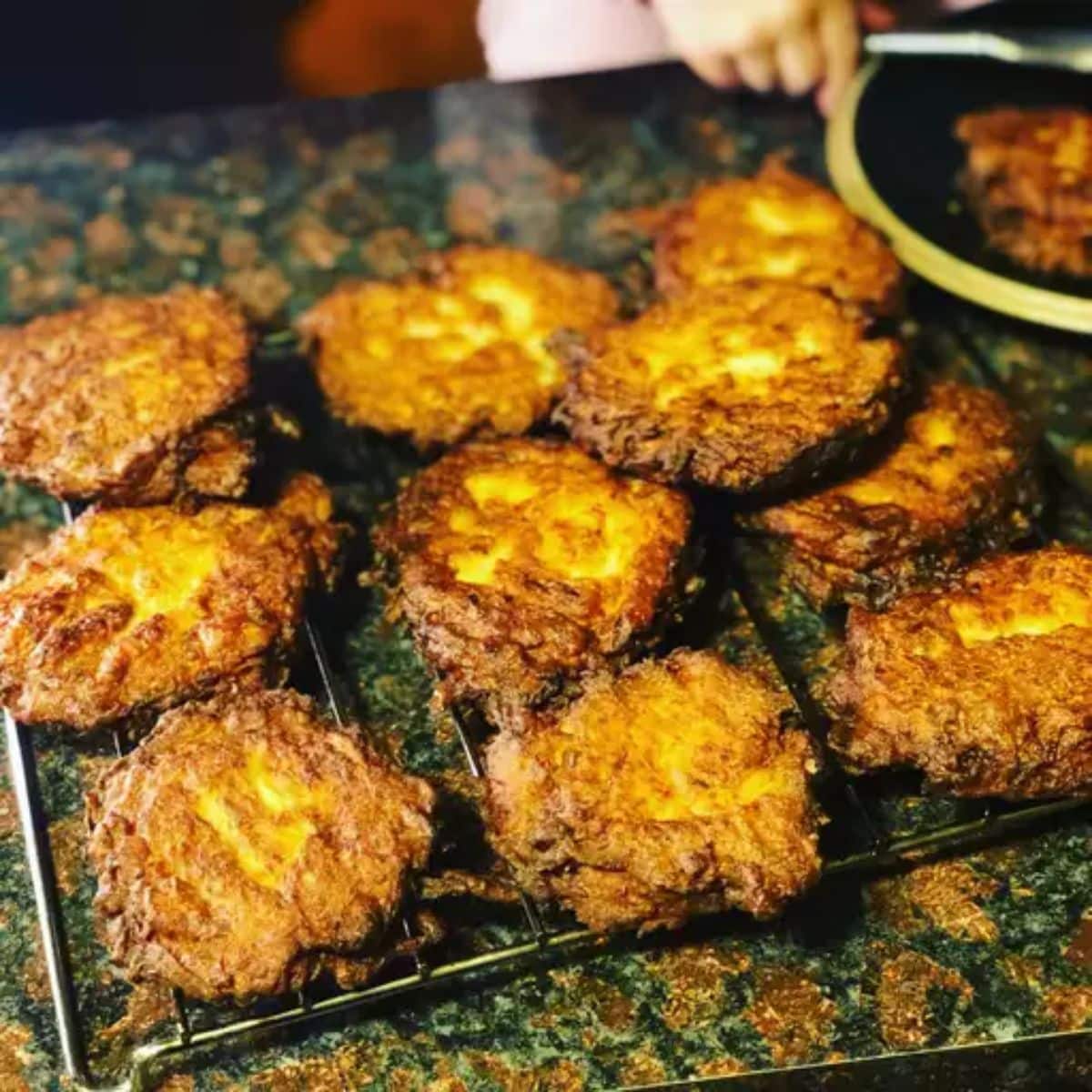 Crispy potato pancakes on a baking grid.