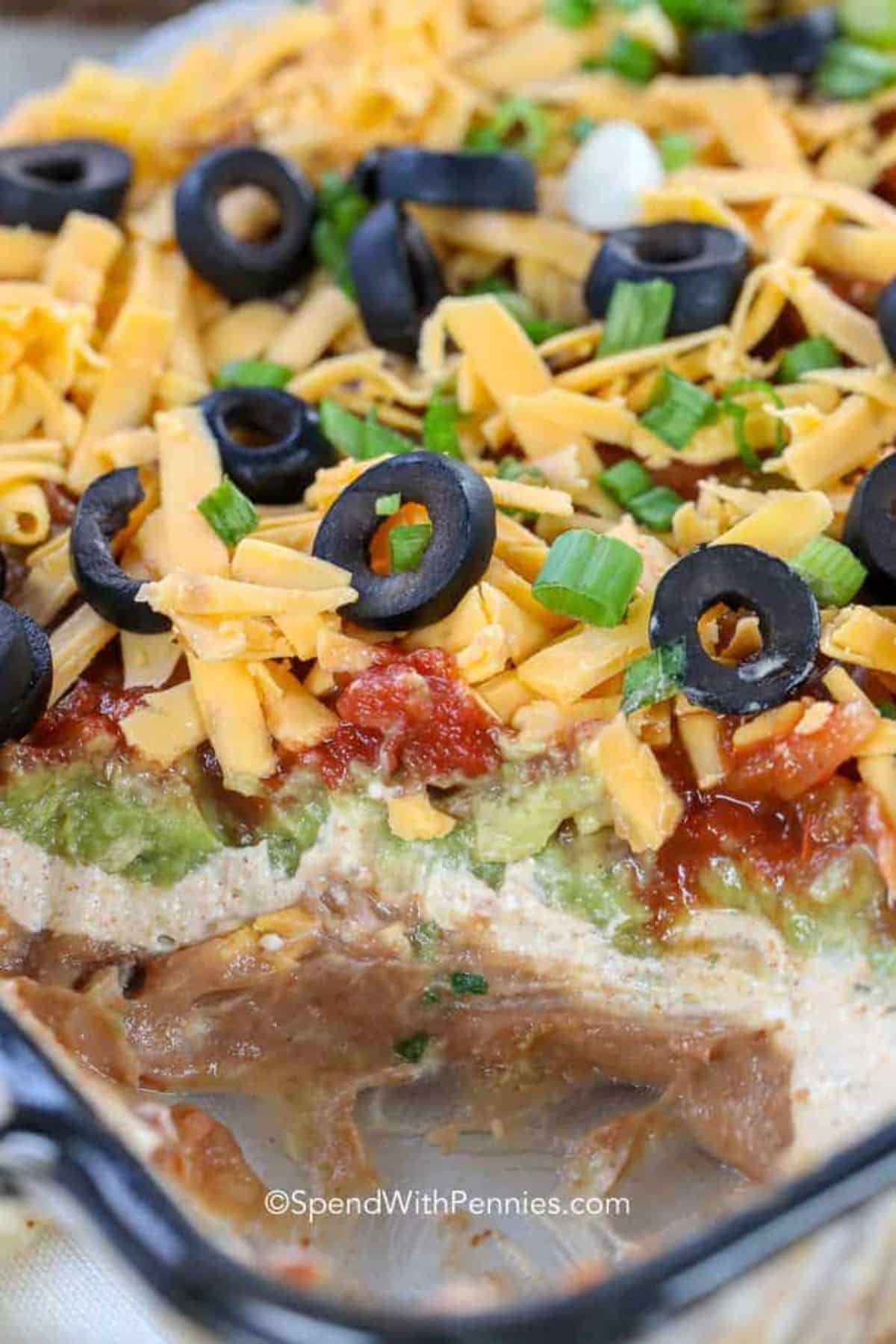 Delicious 7-layer dip in a glass casserole.