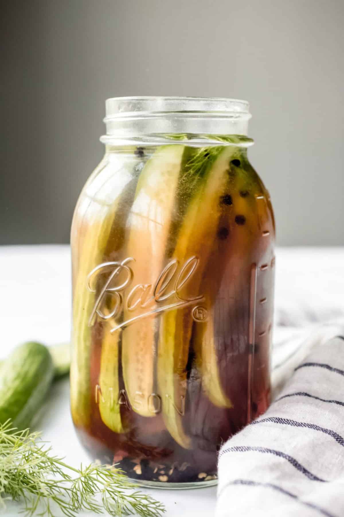 Spicy beer pickles in a glass jar.