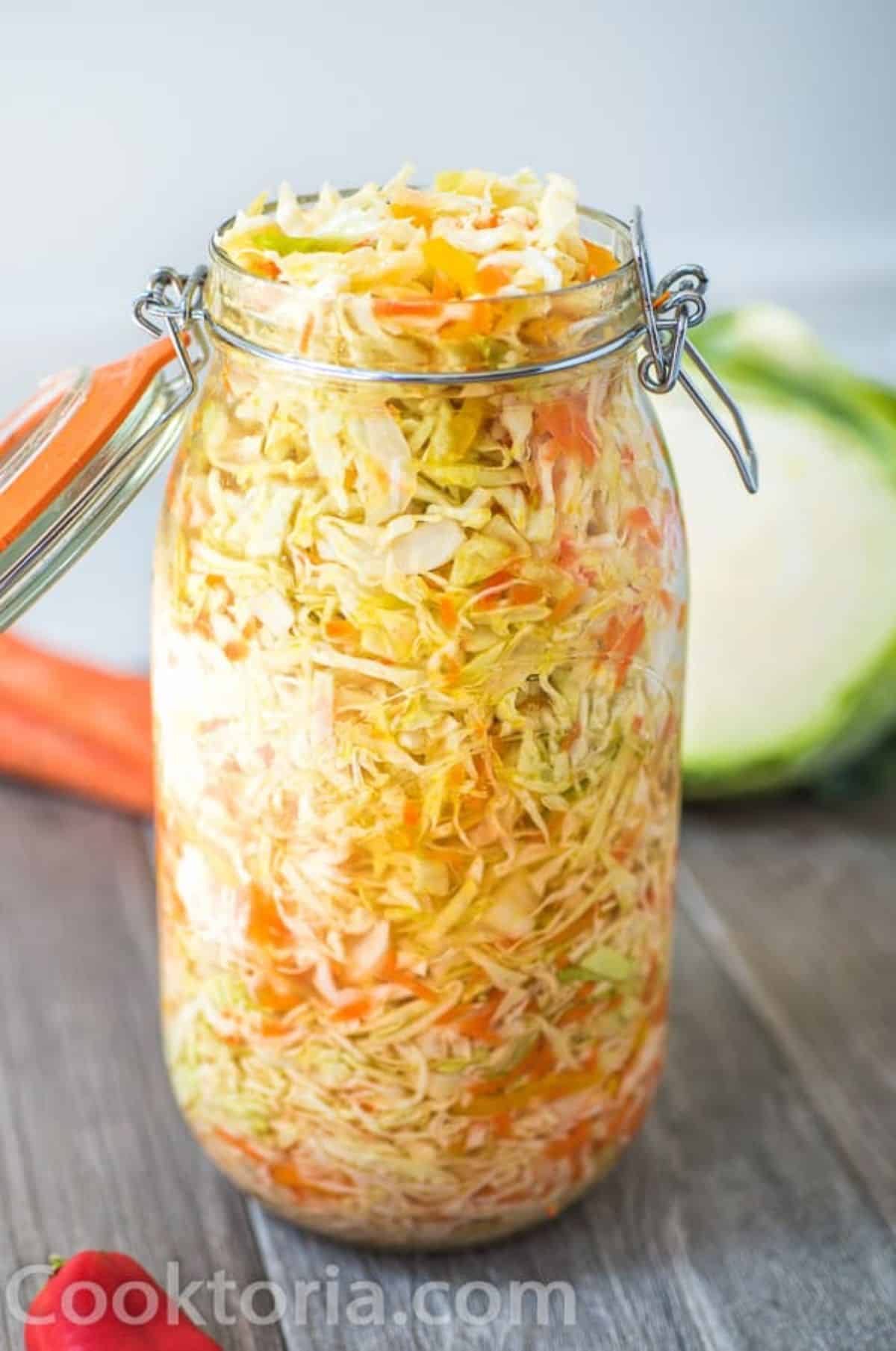 Pickled roots and cabbage in a glass jar.