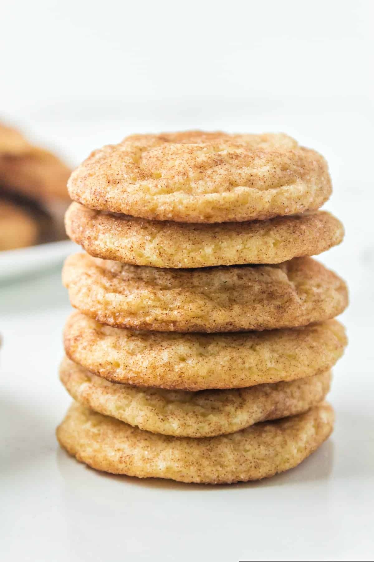 A pile of deliicous snickerdoodles on a white tray.