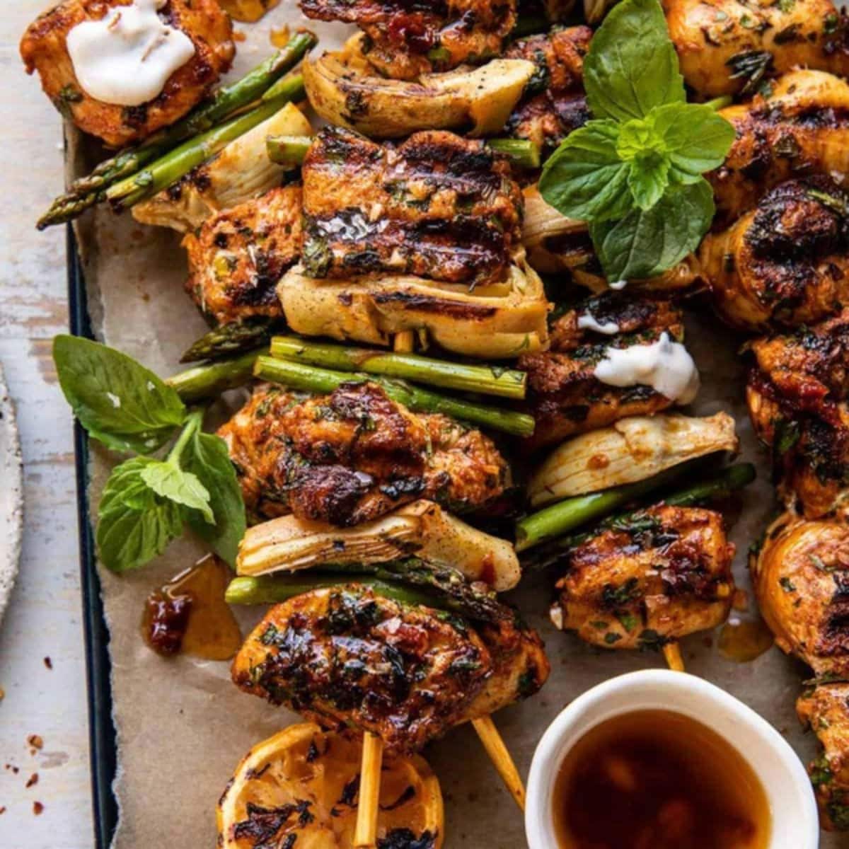 Lemon chicken skewers on a black tray.