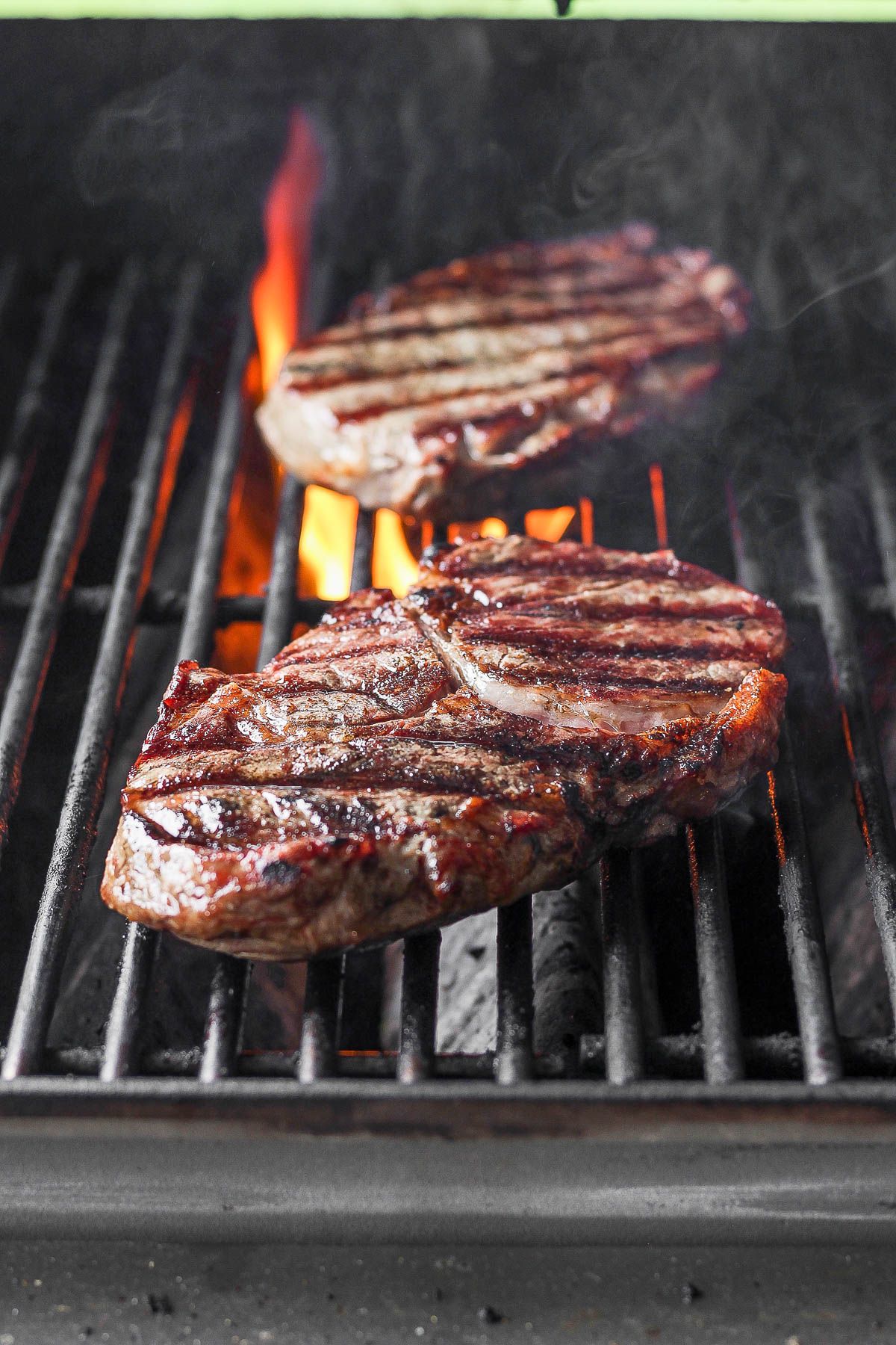 Deliicous grilled steaks on a grill grid.