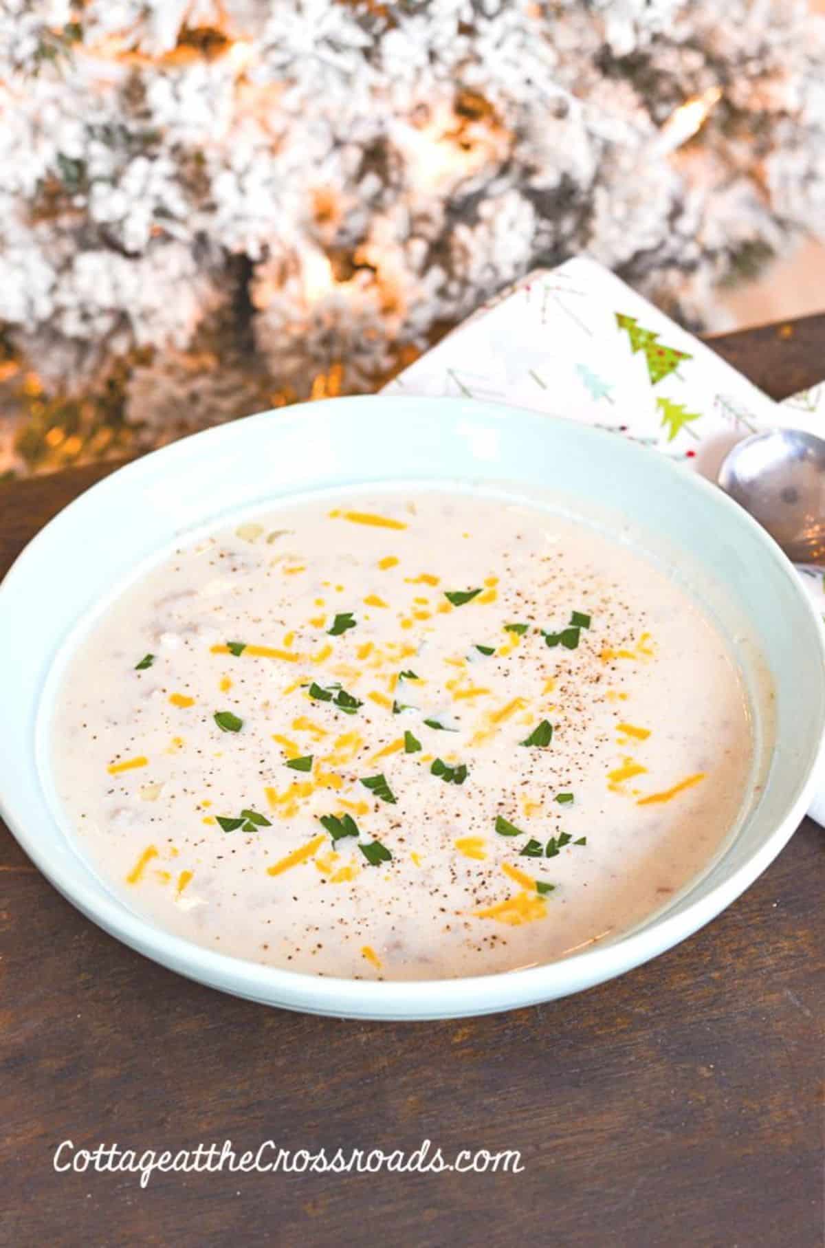 Creamy cauliflower soup with sausage in a white bowl.