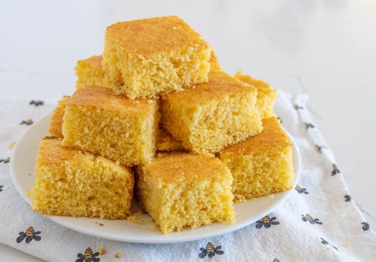 Pieces of scrumptious cornbread on a white plate.