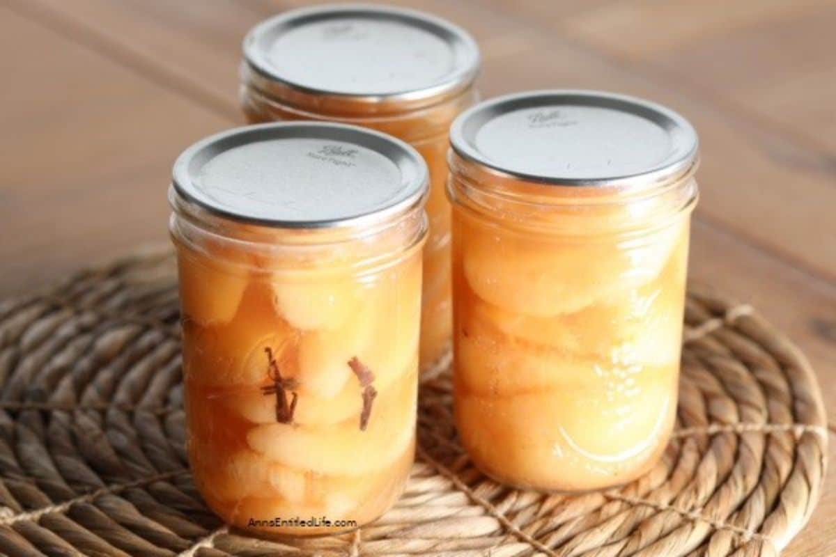 Spiced pears in three glass jars.