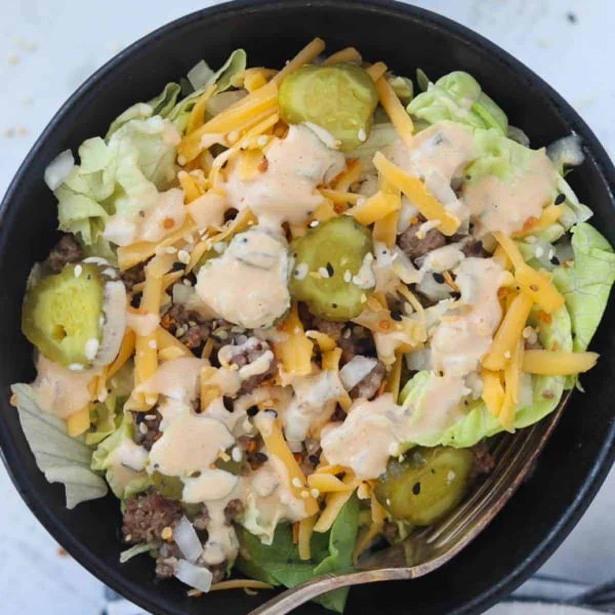 Keto big mac in a black bowl with a fork.