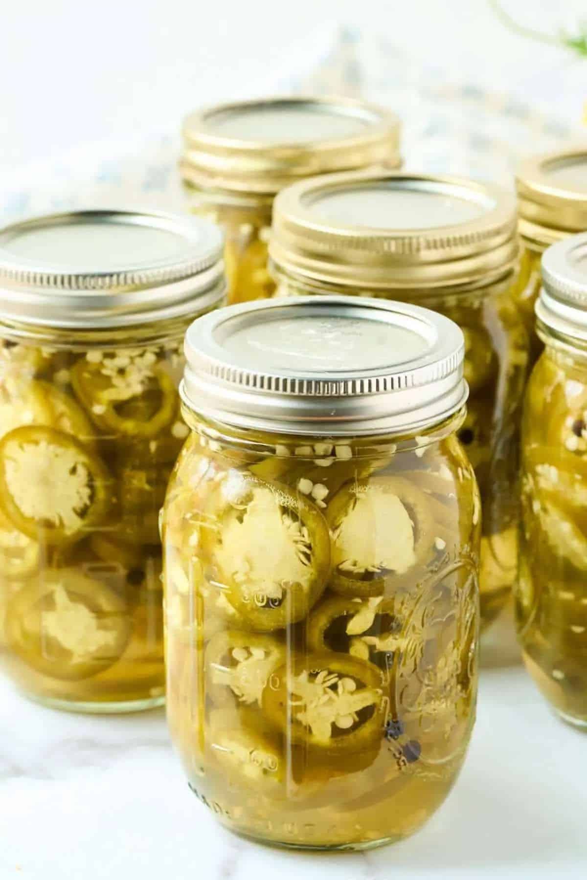 Pickled jalapeno slices in glass jars.