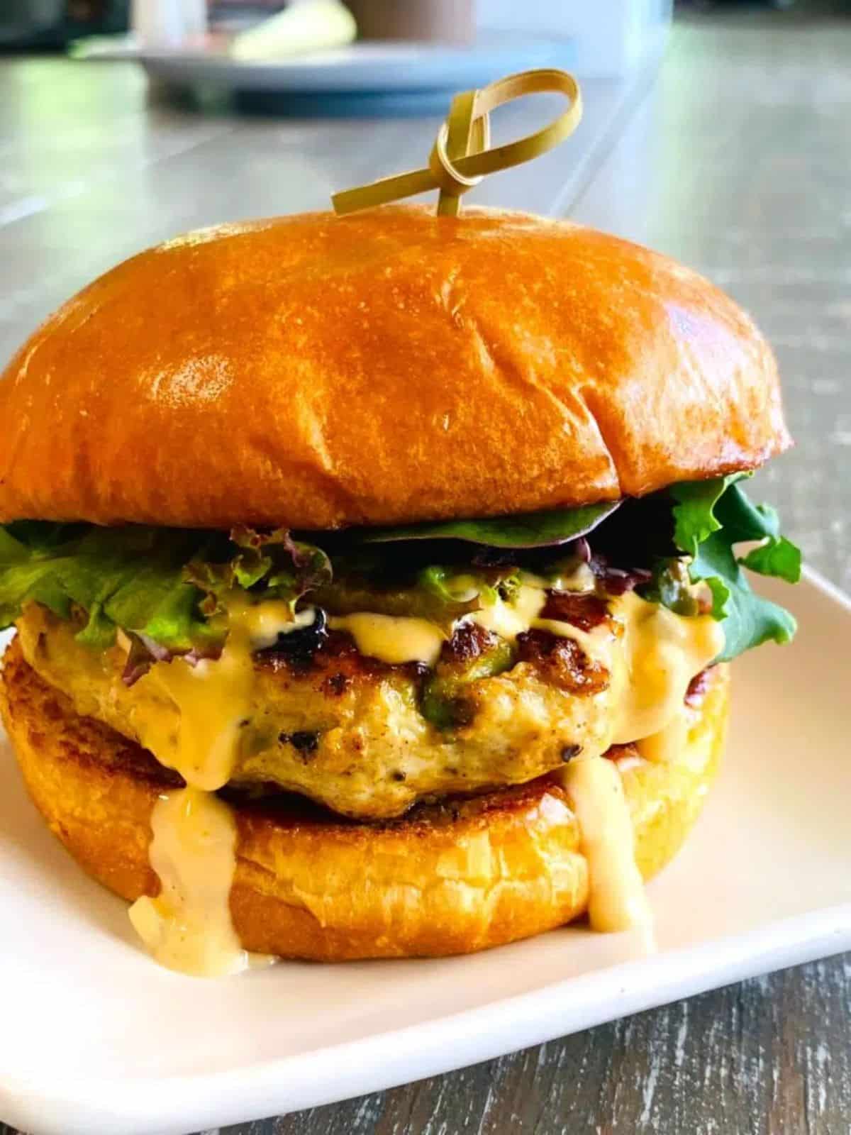 Blackstone chicken avocado burger on a white plate.