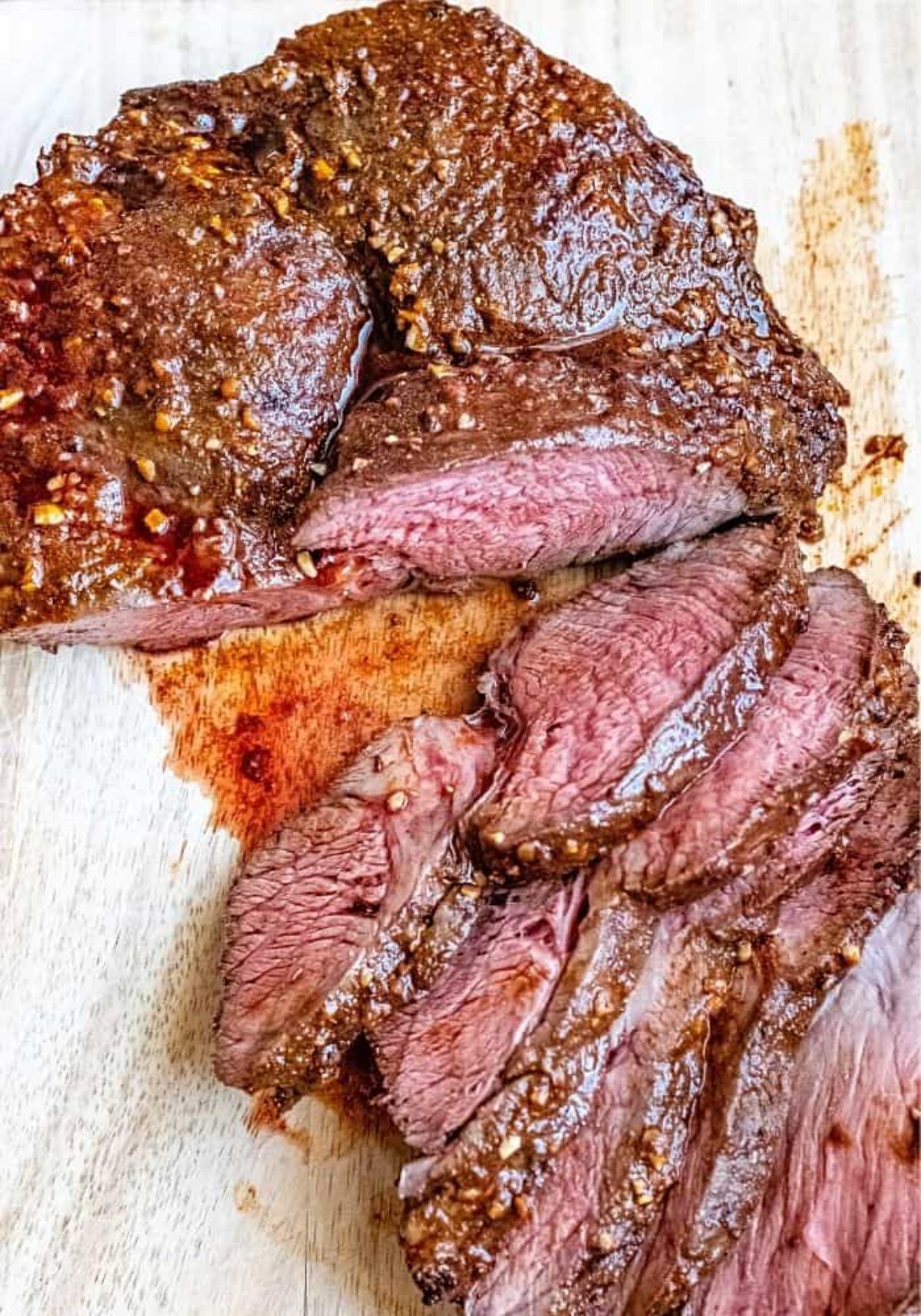 Juicy partially sliced the best sirloin roast on a wooden cutting board.