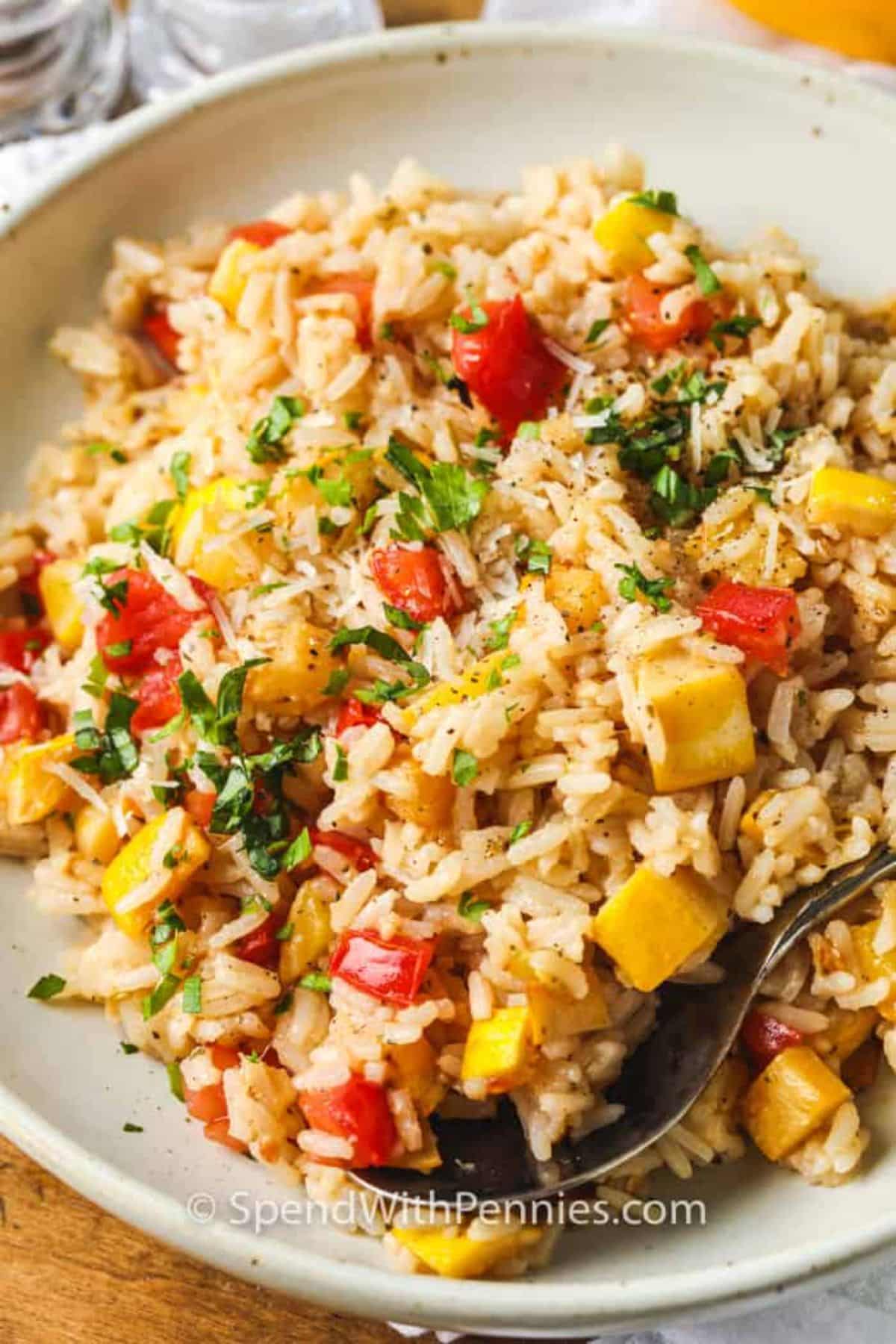 Summer squash rice on a white plate with a fork.