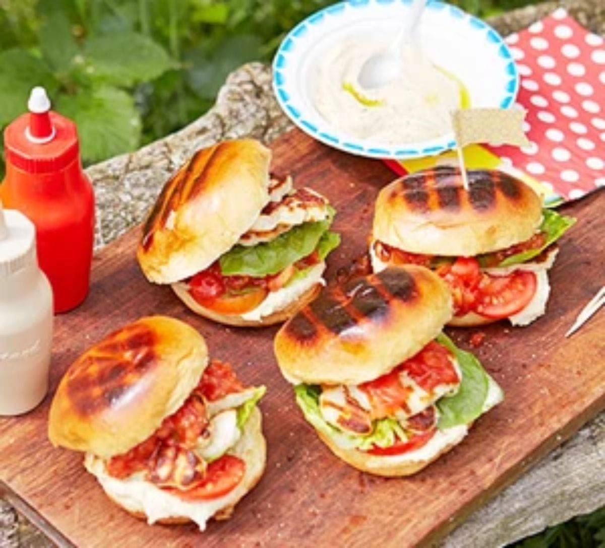 Halloumi burgers on a wooden cutting board.