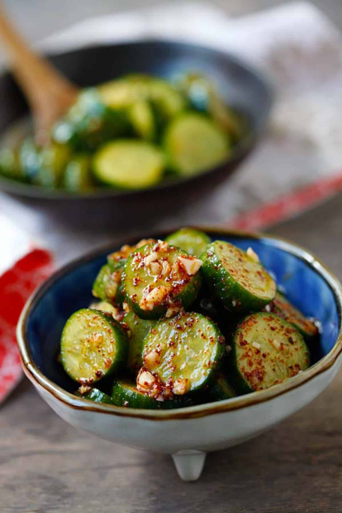 Asian cucumber salad in a small blue bowl.