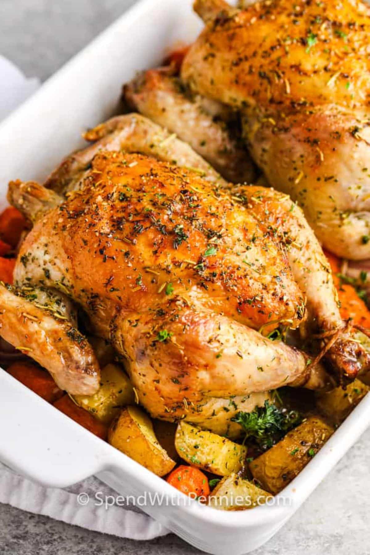 Delicious roast cornish hen in a white casserole.