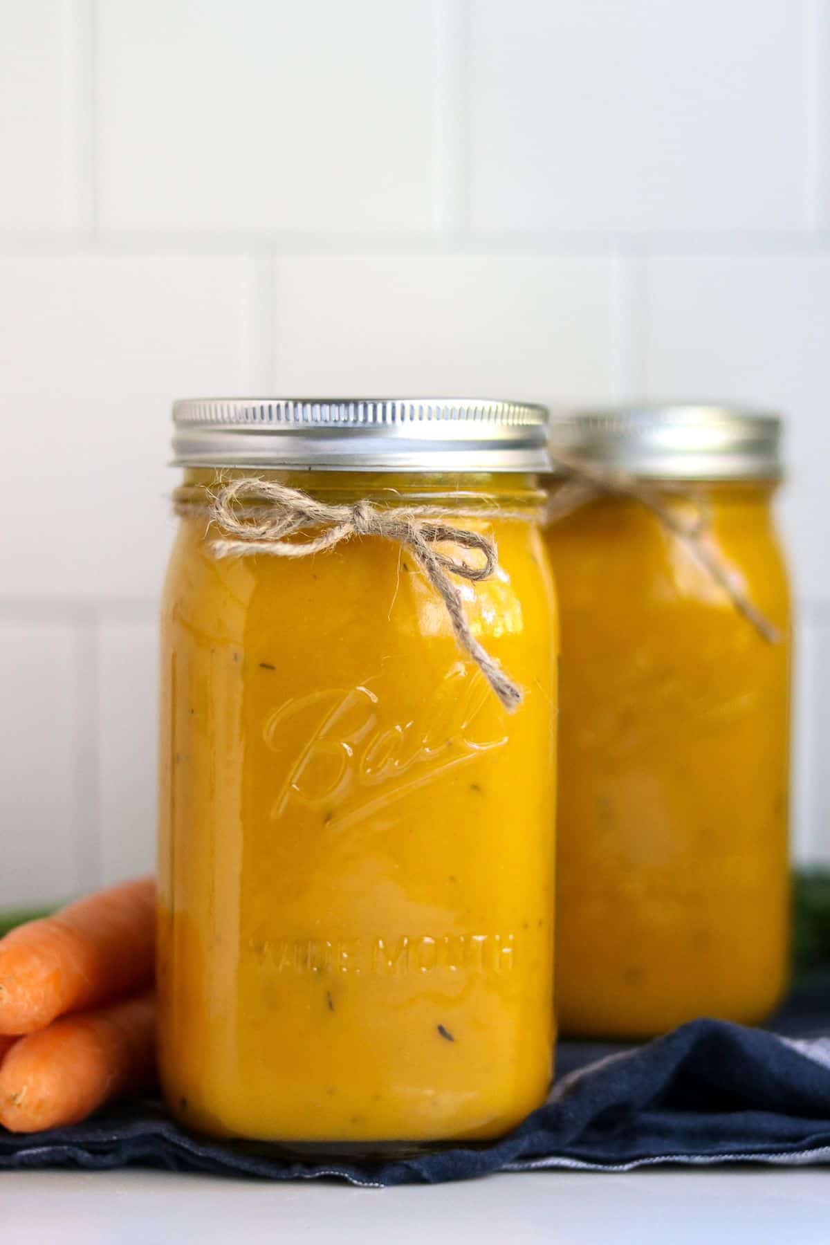 Canned carrot and fennel soup in two glass jars.