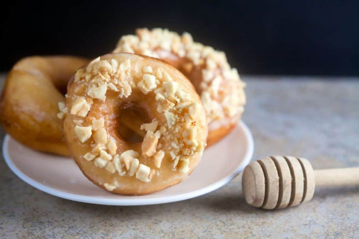 Salted peanut and honey doughnuts on a white plate.