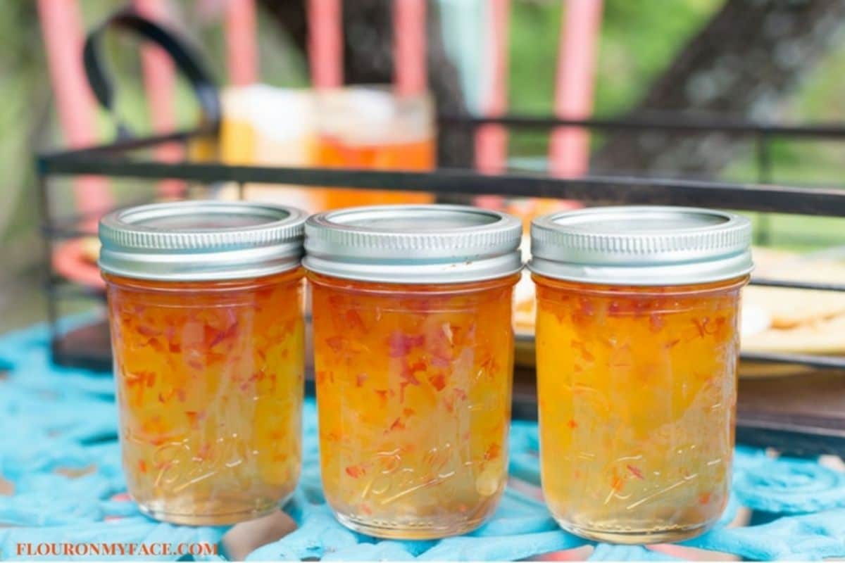 Habanero apricot jelly in three glass jars.