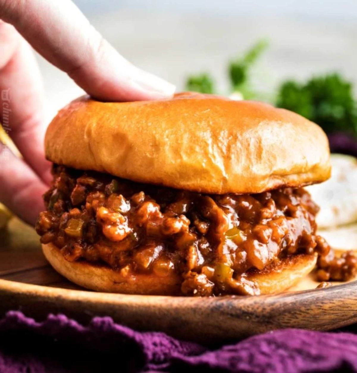 Juicy sloppy joe on a wooden plate.