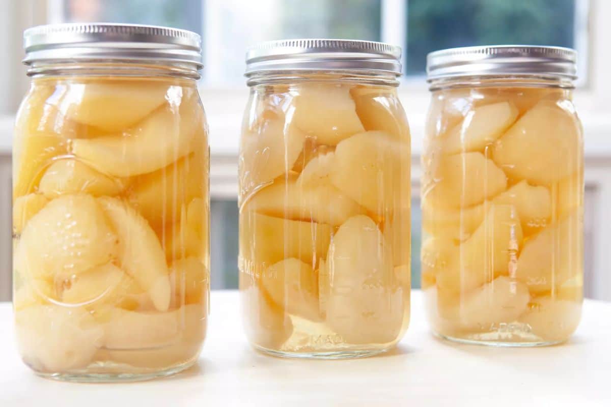 Simple preserved pears in three glass jars.